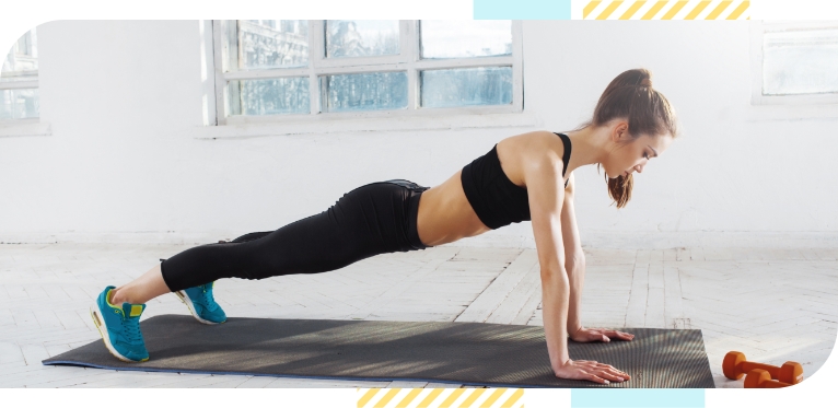 A young woman is exercising on a yoga mat.
